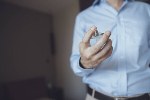 Man looking at the perfume bottle in his hand