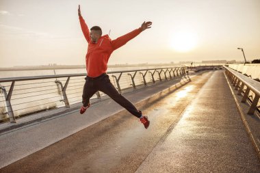 Fit memnun adam bir yaya köprüsü üzerinde atlama