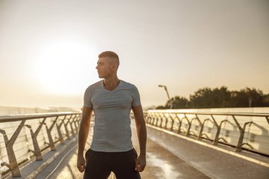 Çekici ciddi kaslı genç adam uzağa bakıyor