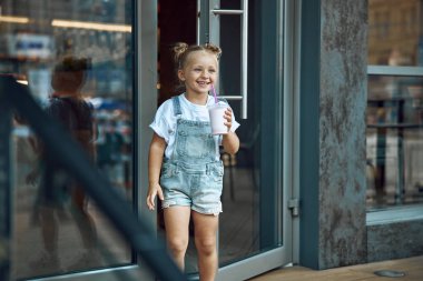 Pozitif çocuk milk shake stok fotoğraf ile kafeden dışarı yürüyüş