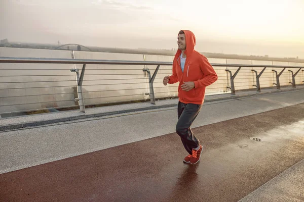 Attractive young runner jogging on a bridge