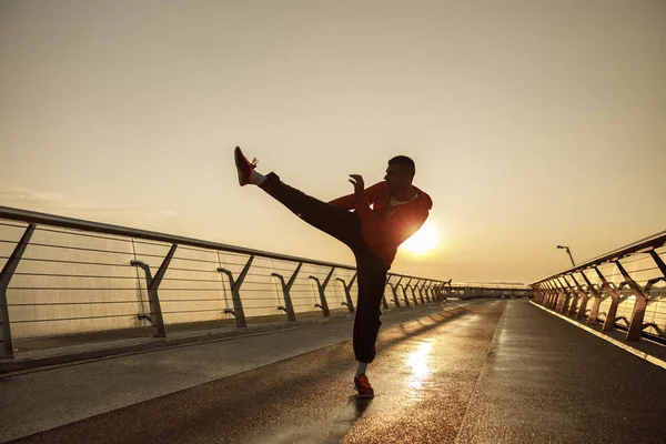 Fokuserad atletisk man utövar på en bro — Stockfoto