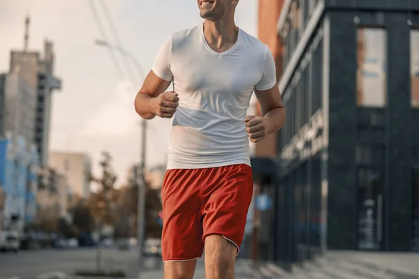Glad manlig atlet jogging på gatan — Stockfoto