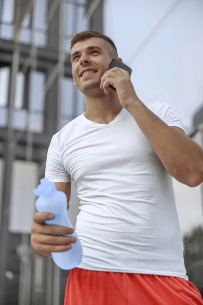 Hombre deportivo sosteniendo una botella de agua — Foto de Stock