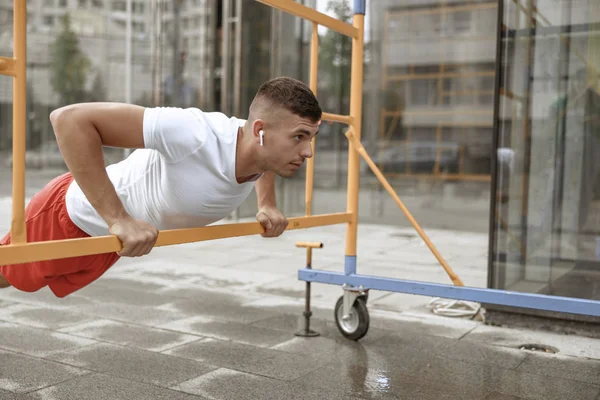 Atletisk attraktiv ung man gör push-ups utomhus — Stockfoto