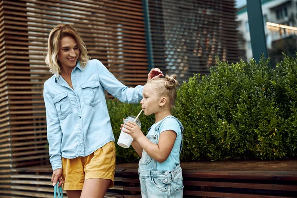 Madre viendo a su hija beber leche batido foto de stock —  Fotos de Stock