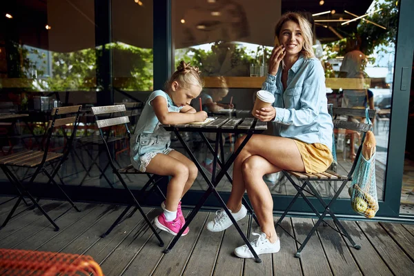 Mujer disfrutando de la charla telefónica y su hija dibujo foto de stock — Foto de Stock