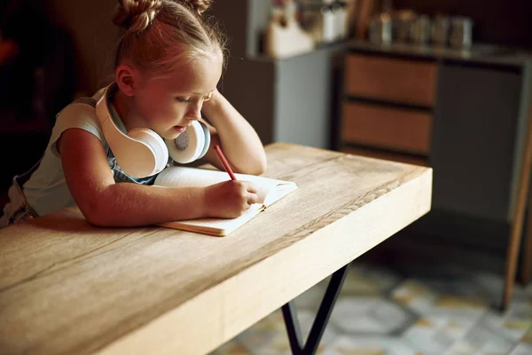 Menina na mesa desenho em seu caderno de fotos stock — Fotografia de Stock