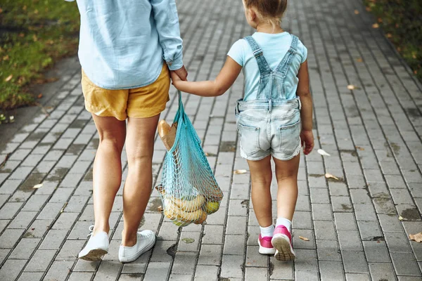 Kvinna och flicka gå med shoppingväska Stock Foto — Stockfoto