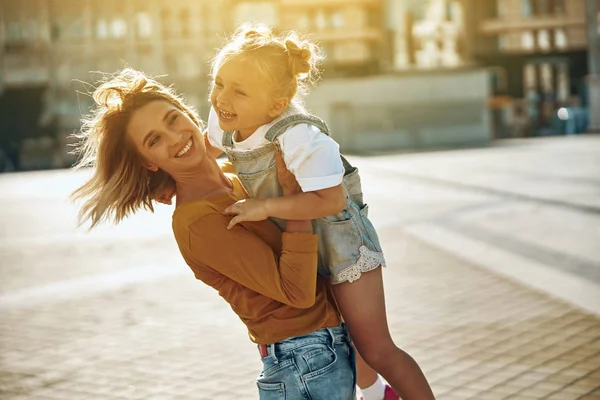 Щаслива жінка поклала свою дочку на повітряний потік фото — стокове фото