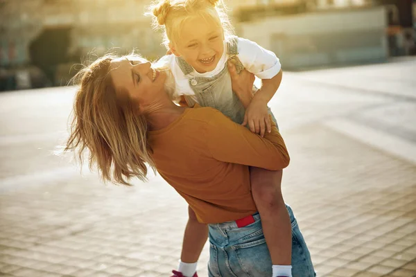 Щаслива дитина в обіймах своєї матері фото — стокове фото