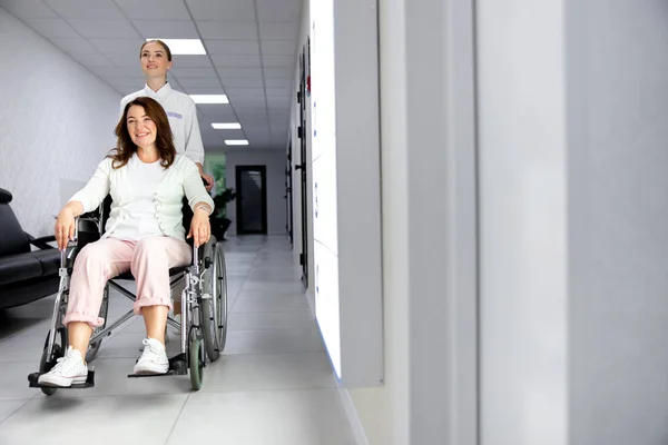 Женщина-инвалид с помощью медсестры на фото на складе клиники — стоковое фото
