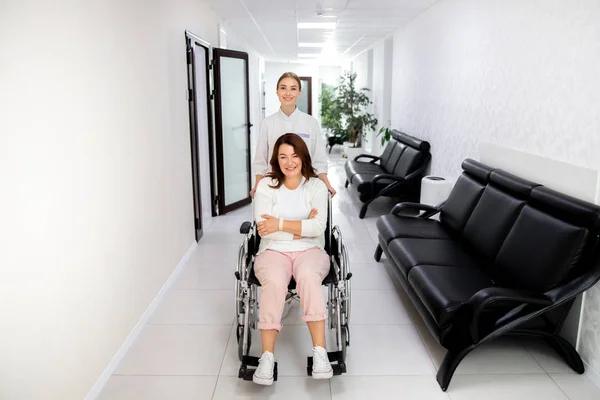 クリニックストック写真で障害のある女性を助ける笑顔の医師 — ストック写真