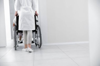 Doktor hastayı tekerlekli sandalyeye mahkum ediyor.