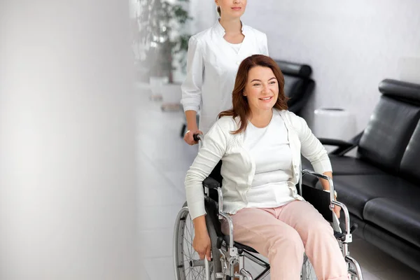 Feliz dama va en silla de ruedas en el hospital foto de stock — Foto de Stock