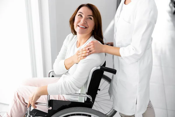 Mulher sorridente está olhando para o médico no lobby — Fotografia de Stock