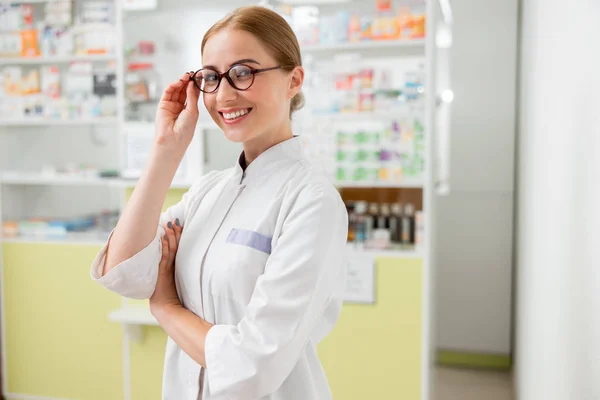 Feliz médico femenino está de pie en la farmacia — Foto de Stock