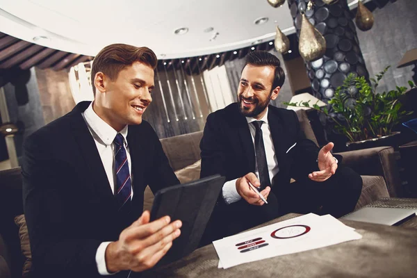 Socios amistosos sonriendo mientras discuten su proyecto — Foto de Stock