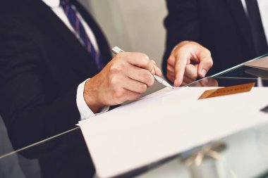 Belgeyi imzalayan genç adam ve iş ortağı belgeyi işaret etti