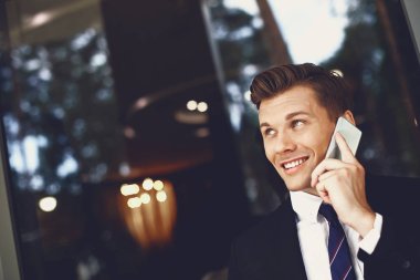 Telefon konuşması yaparken gökyüzüne bakan rahat genç adam