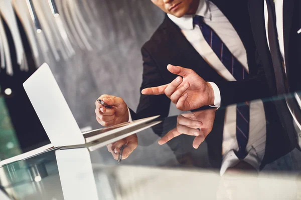 Un hombre serio mirando la pantalla mientras su colega lo señala —  Fotos de Stock