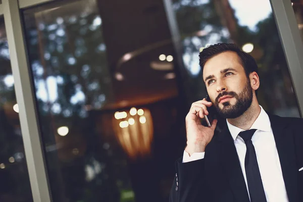 Komoly szakállas férfi keres nyugodt, miközben beszél a telefon — Stock Fotó