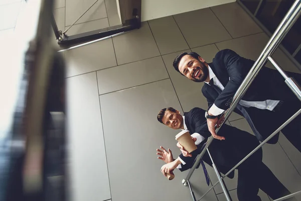 Cintura para cima de colegas alegres sorrindo enquanto bebe café — Fotografia de Stock