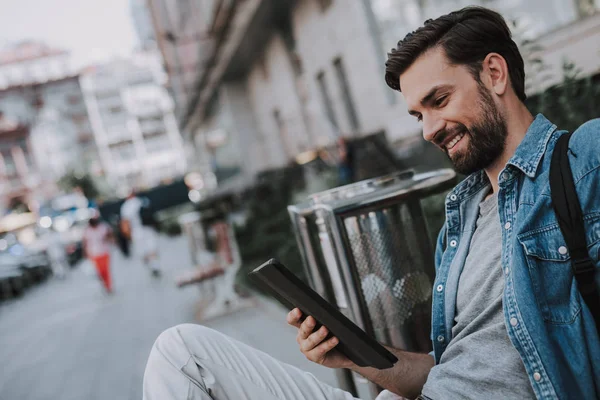 Uomo in uscita guardando il dispositivo digitale all'aperto — Foto Stock