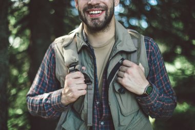 Ormanın yeşil ağaçlarında duran gezgin adam.