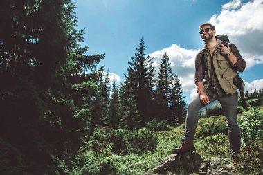 Yeşil dağ tepesinde duran gezgin adam