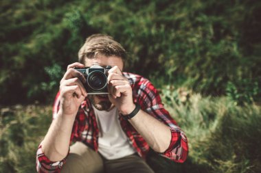 Dağ tepesinde fotoğraf çeken bir gezgin.