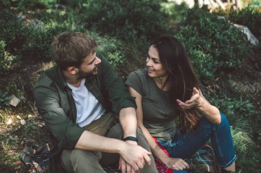 Genç çift yeşil tepede dinleniyor.