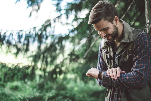 Ο άνθρωπος κοιτάζει το ρολόι του ταξιδεύοντας στο δάσος — Φωτογραφία Αρχείου