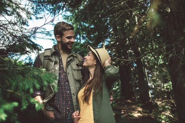 Cestovatel veselý pár stojící v zeleném lese — Stock fotografie