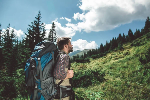 Traveler man climbing up of green mountain hill — ストック写真