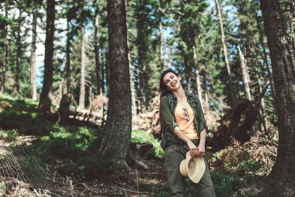 Молодая улыбающаяся женщина позирует в зеленом лесу — стоковое фото