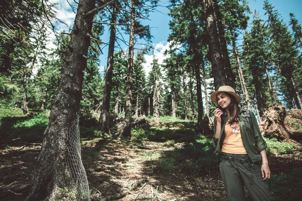 Glimlachende vrouw spreekt per radio in het bos — Stockfoto