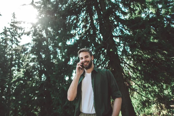 Ταξιδιώτης που μιλάει τηλεφωνικά στο πράσινο δάσος — Φωτογραφία Αρχείου