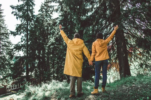 Reizigers paar begroeten iemand in regenachtig weer — Stockfoto