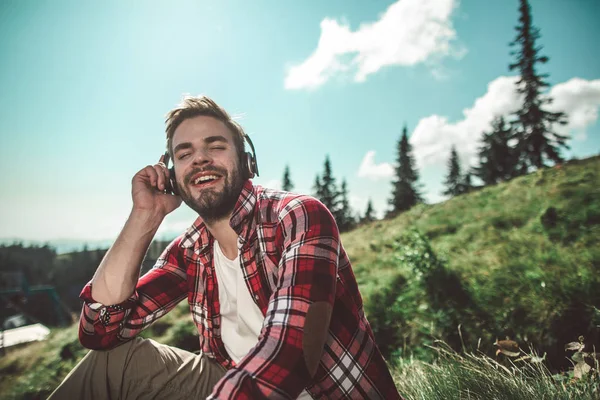 Resenär man lyssnar musik på berget kulle — Stockfoto