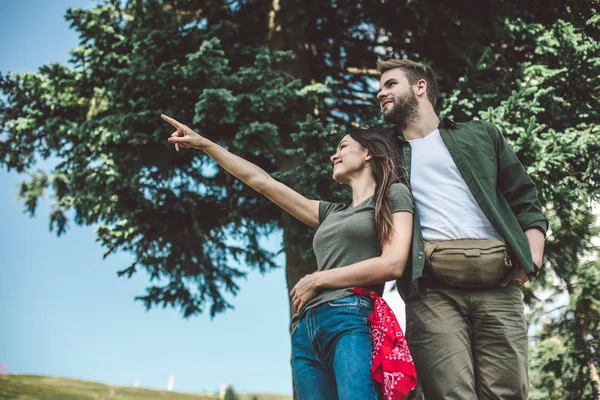 Casal amante olhando para algo na colina verde — Fotografia de Stock