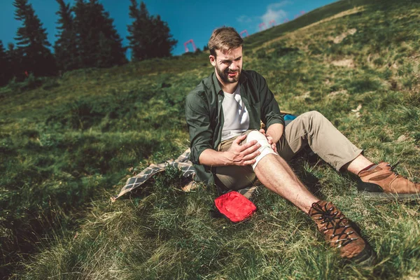 Traveler man making bandage of his leg himself — ストック写真