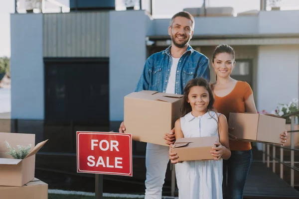 Positiv familj innehav papperslåda nära deras hus — Stockfoto