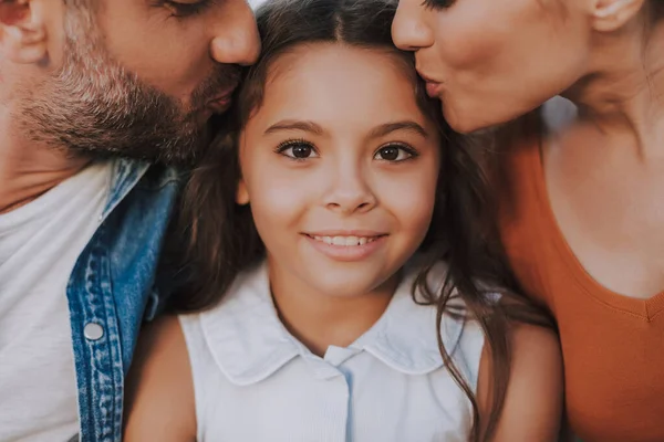 Close up of a nice girl receiving love of her parents — ストック写真