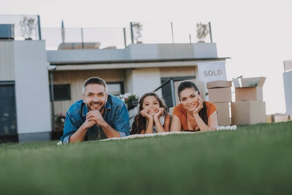 Agradable familia sonriente descansando sobre la hierba — Foto de Stock