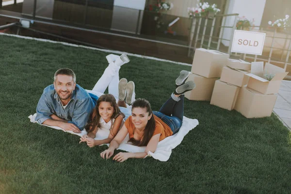 Positiv en unge familj som ligger på gräset — Stockfoto