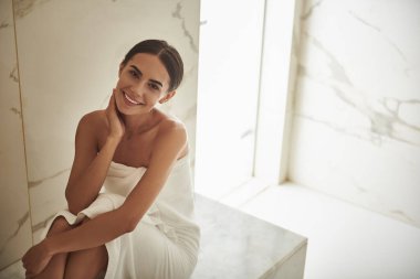 Hamamda oturup gülümserken güzel bir bayan.