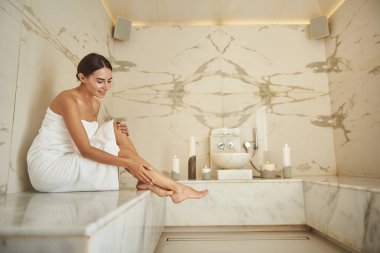 Hamam ameliyatından sonra neşe saçan kadın rötuşlarına dokunuyor.