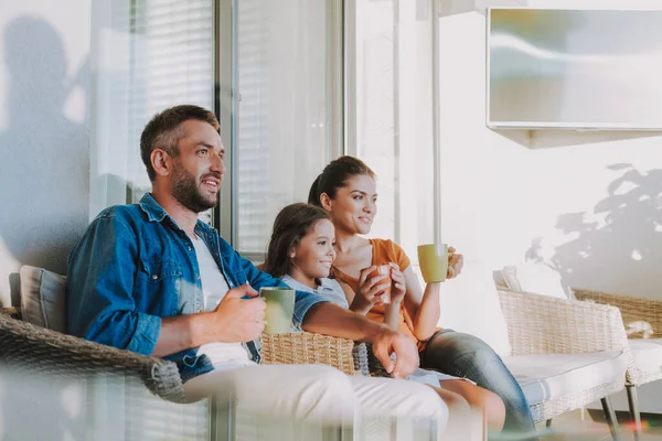 Příjemná usměvavá rodina odpočívající společně doma — Stock fotografie