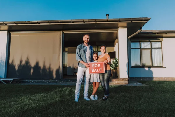 Täysi pituus iloinen ystävällinen perhe myy talonsa — kuvapankkivalokuva